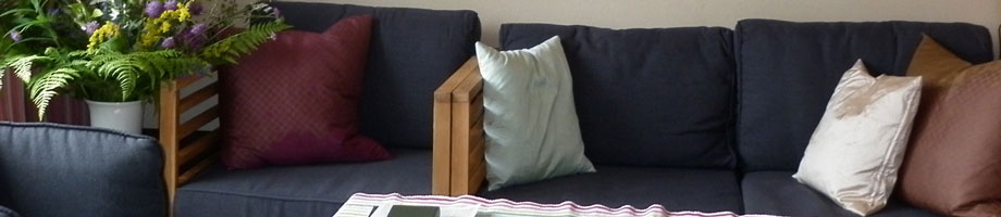 Blick auf Couch und Ofenbank im Wohnzimmer