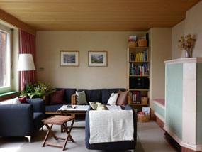 Sitzecke mit Sofa und Kachelofen